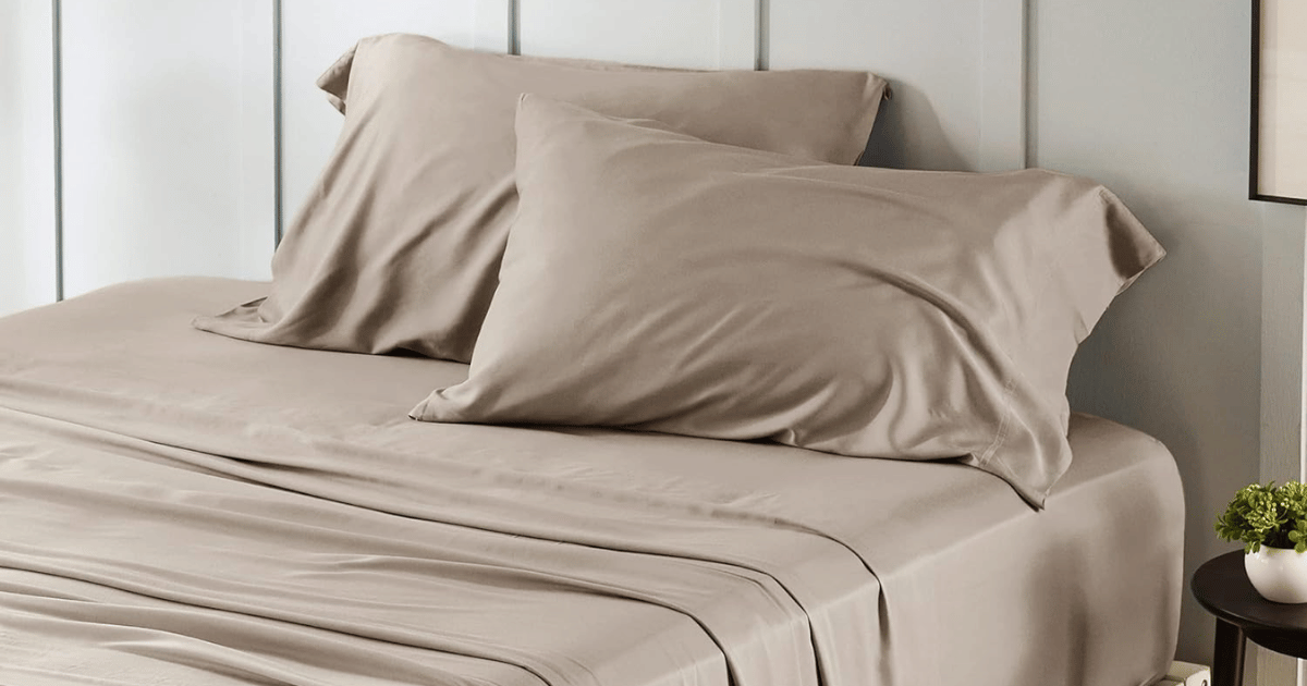 Bedsure satin pillowcase set in dusty rose on styled bed with crisp white linen and trailing plant